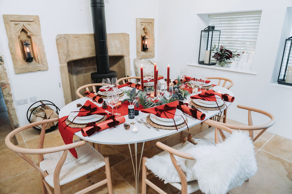 Nordic-inspired Advent tablescape showing rich red tones and natural wood textures by Noble & Nordic.