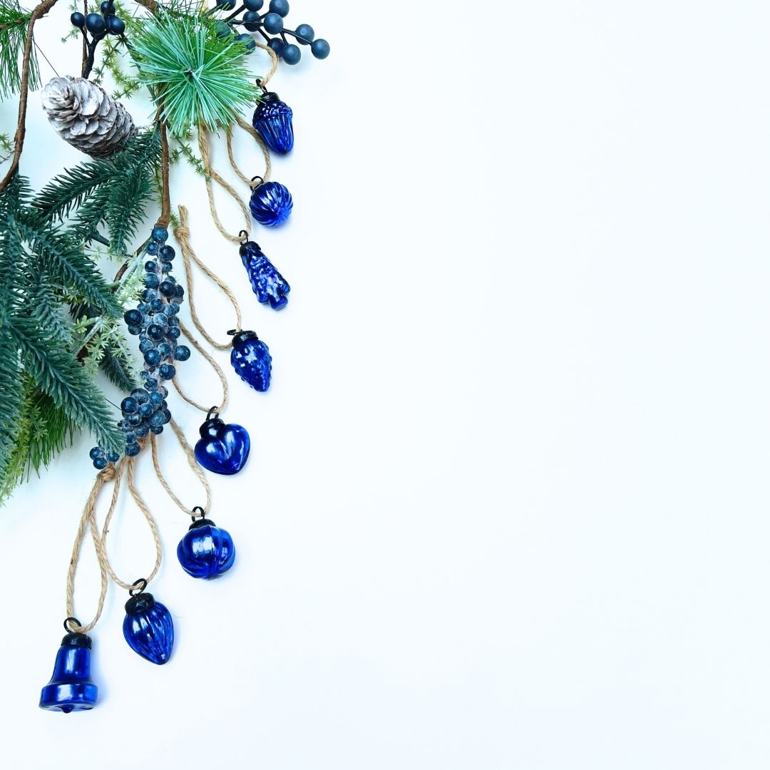 Decorative Christmas garland with blue mini Christmas glass baubles and pine cone Christmas garland on a white background