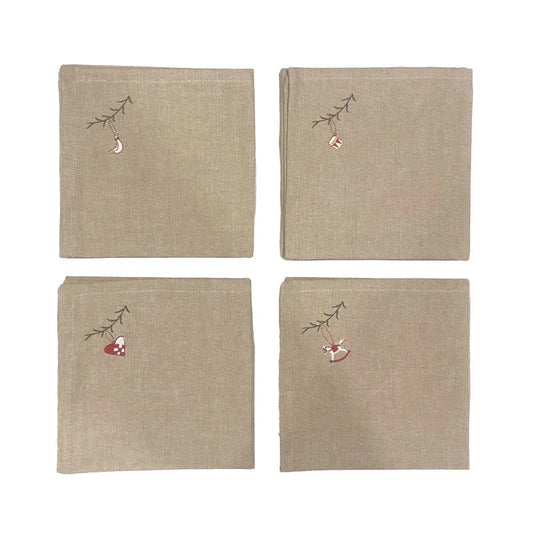 Four beige linen napkins arranged in a 2x2 grid on a white background. Each napkin features a small embroidered Christmas motif in the top-left corner, including a hanging ornament and a red-and-white stocking on a small branch.