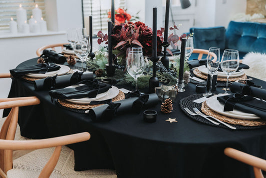 Elegant black table setting with black candles and black candle holders, Christmas decor in a modern living room by Noble & Nordic.