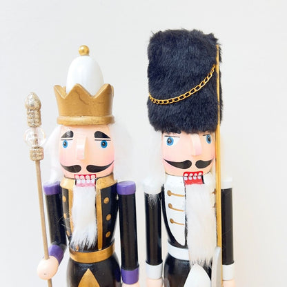 Pair of luxury Nordic nutcrackers in black, white, and gold uniform.