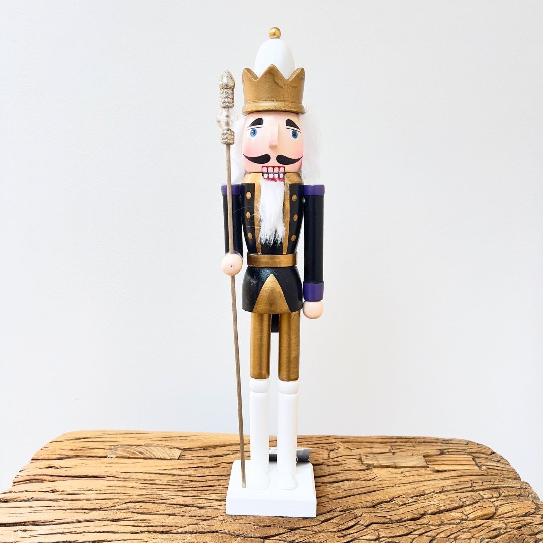 Wooden nutcracker figurine with a crown on a wooden surface