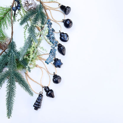 Decorative string with black baubles and christmas garland pine branches background