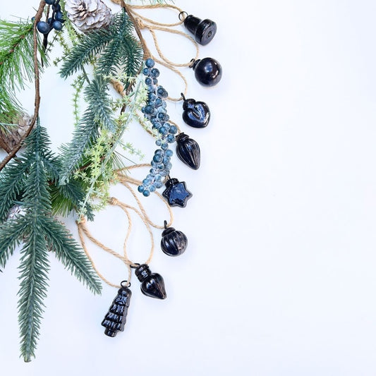 Decorative string with black baubles and christmas garland pine branches background