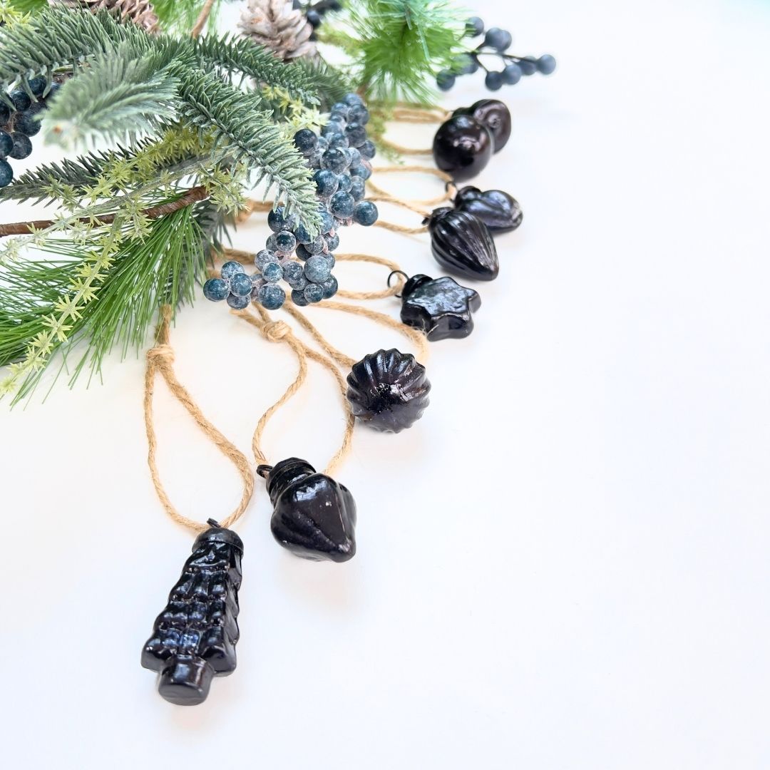 Decorative Christmas garland with black tree-shaped and mixed shaped baubles and Christmas garland on a white background