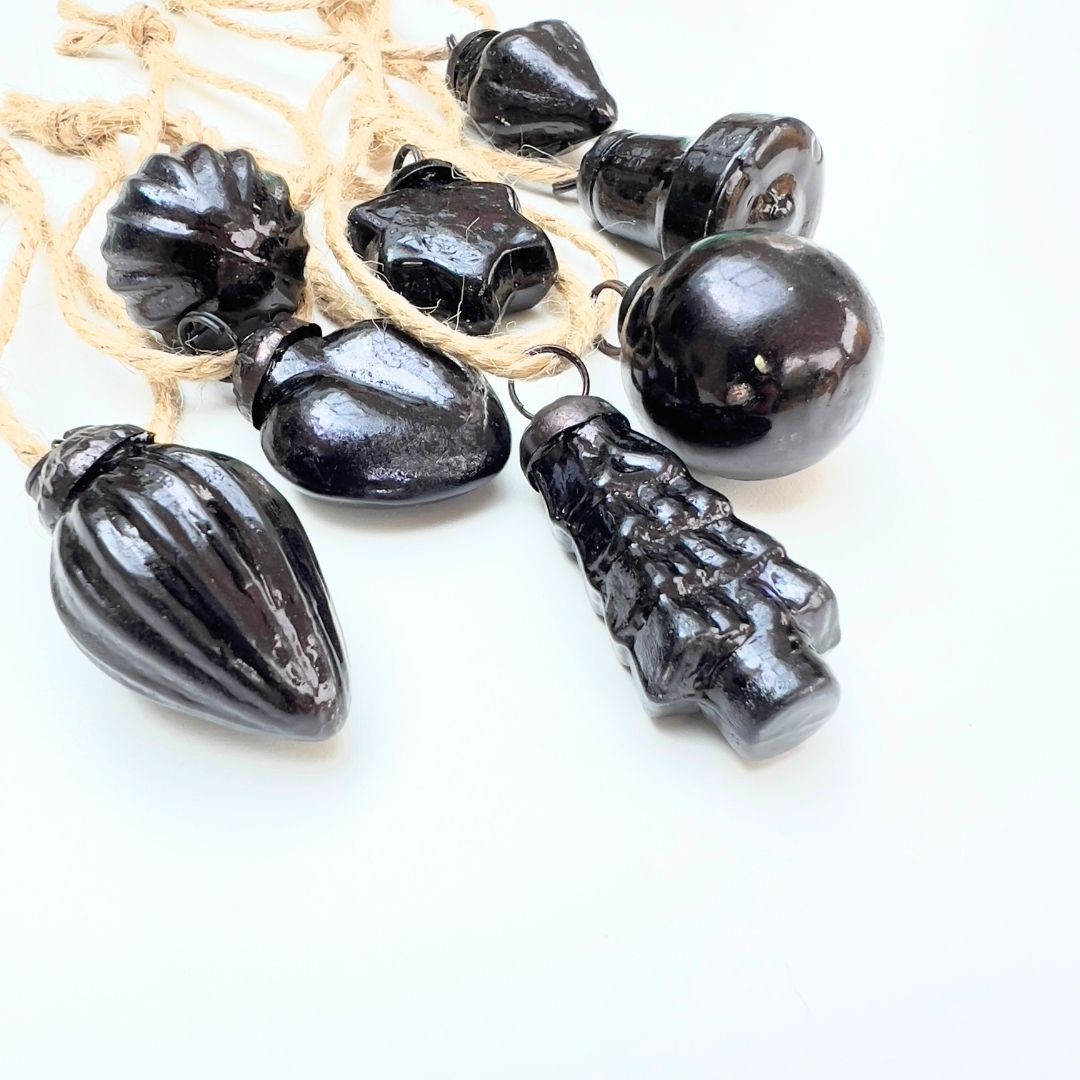 Black decorative Christmas baubles on a white background