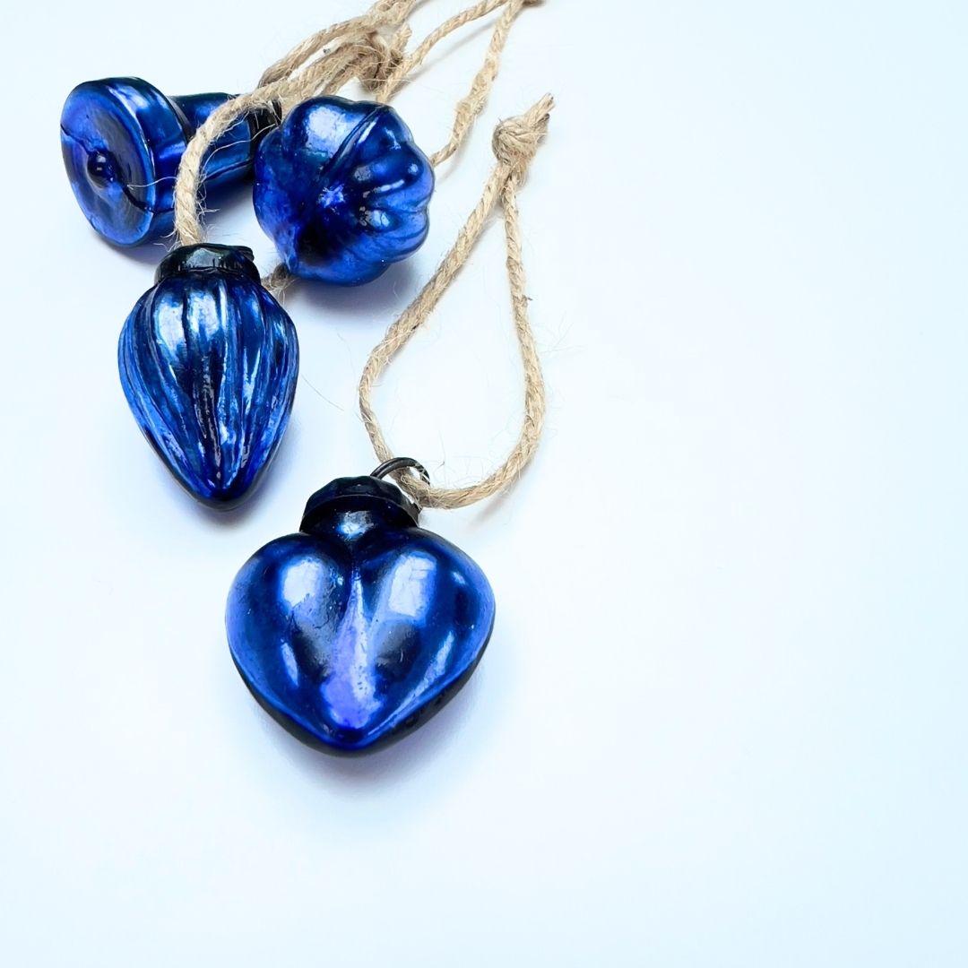 Mini Christmas baubles mixed-shaped with jute string on a white background