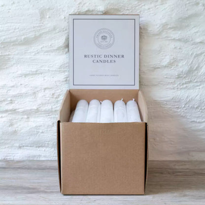Box of rustic white dinner candles displayed in minimalist kraft packaging — simple Scandinavian elegance by Noble & Nordic.